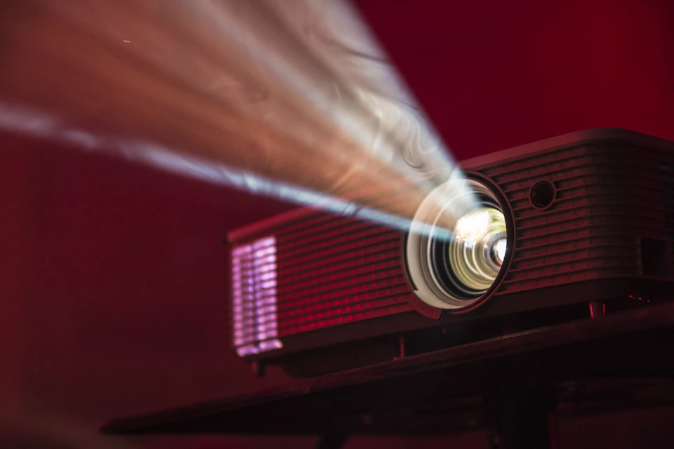 Een projector met een verlichte lens in een donkere ruimte